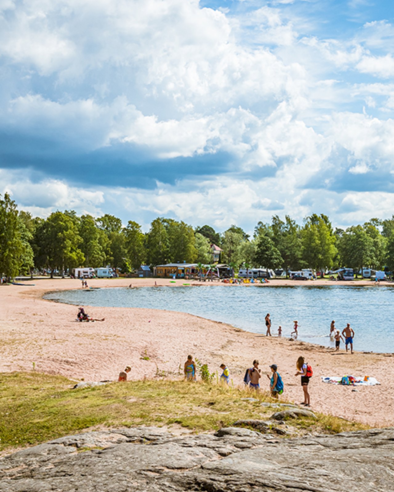 Lapsiperheitä nauttimassa kesäpäivästä Rauman uimarannalla.